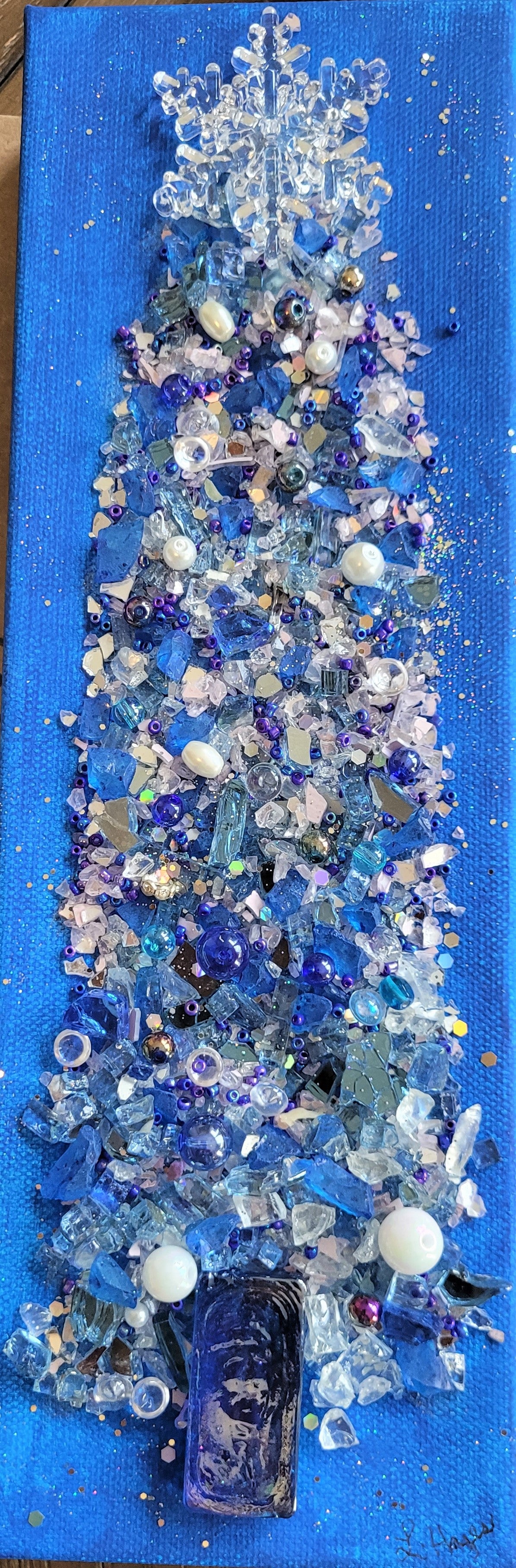 Decorative piece with blue and white beads on a blue background