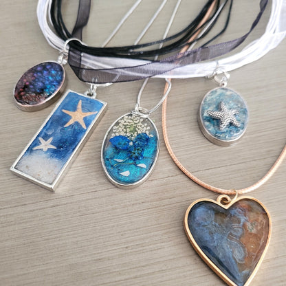 Collection of necklaces with various pendants on a wooden surface