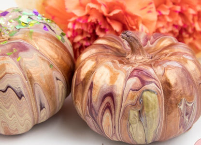 Two marbled pumpkins with a colorful background